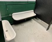 The mens bathroom underneath my local high schools football stadium bleachers still uses vintage 1950s porcelain piss troughs from beg school s