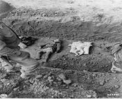 An American soldier looks down at the bodies of children found at the Mittelbau-Dora concentration camp, 14 April 1945. German civilians were forced to bury them. Photo by D.P. Eliot. from 14 melayu