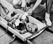 A boy scout tending to a toddler injured by Japanese bombing at South Station, Shanghai, China, 28 August 1937 from toddler lolibo