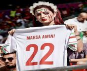 Iranian spectator showing football shirt with Mahsa Amini name written on it - Iran and wales match from sxs iran