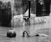 Bangladesh, September 1998after severe flooding from monsoon rains a woman swims through flooded streets in a Dacca neighbourhood to fetch drinking water, almost submerged from bangladesh chamet kapil shows